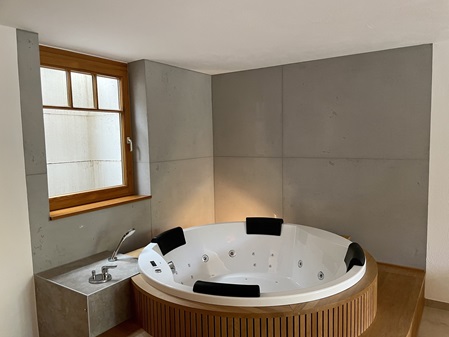 Whirlpool mit Holzeinfassung und Wände in Sichtbetonoptik