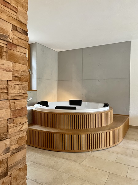 Whirlpool mit Holzeinfassung und Wände in Sichtbetonoptik